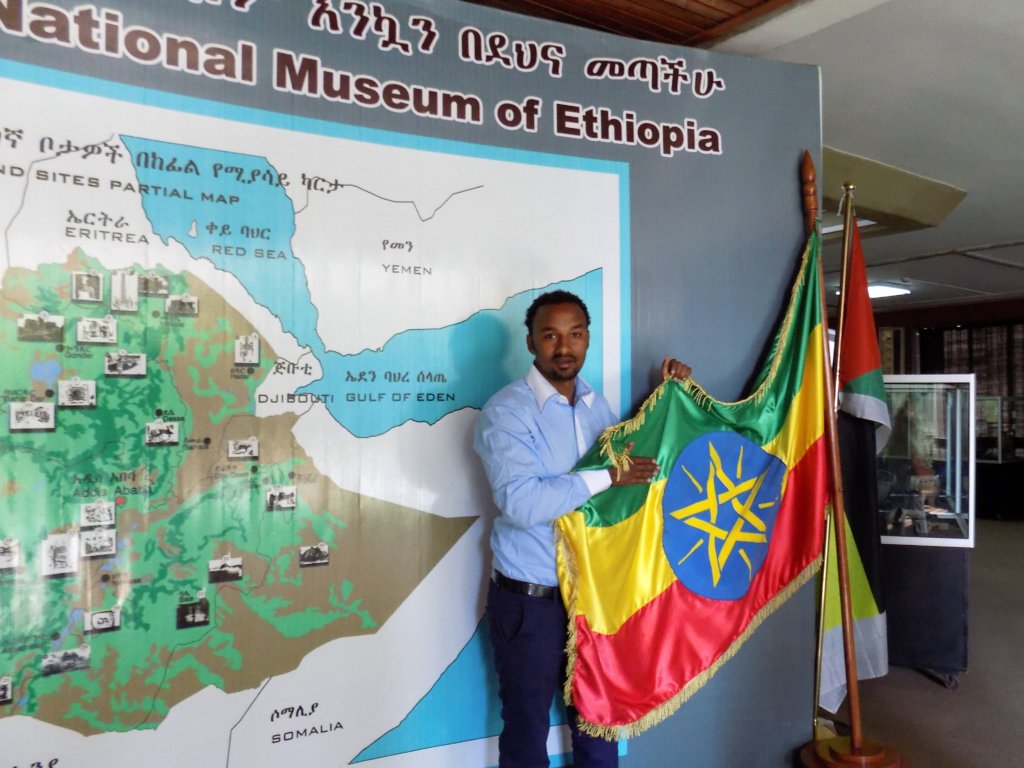 This photo shows our guide, Yuhn holding up the Ethiopian flag against a background of a map of Ethiopia