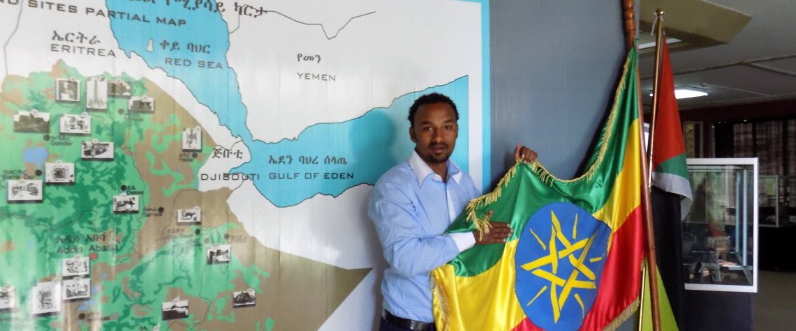 This photo shows our guide, Yuhn holding up the Ethiopian flag against a background of a map of Ethiopia