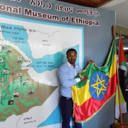 This photo shows our guide, Yuhn holding up the Ethiopian flag against a background of a map of Ethiopia