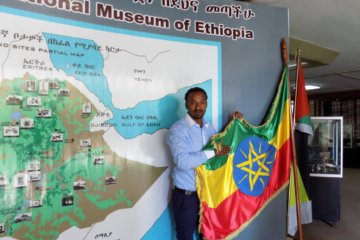 This photo shows our guide, Yuhn holding up the Ethiopian flag against a background of a map of Ethiopia