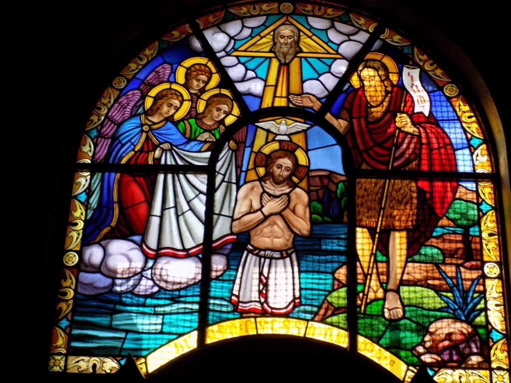 This photo shows a beautiful stained glass window depicting the story of the baptism of Jesus by John the Baptist