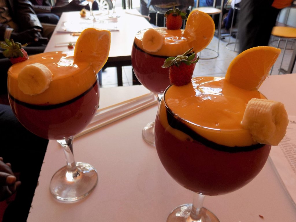 This photo shows three glasses of special juice; layers of fruit juice topped with custard-like ice-cream and fresh fruit