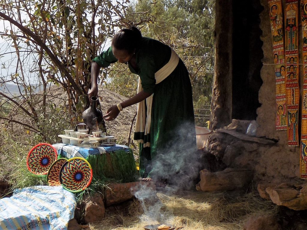 This photo shows a lady pouring coffee