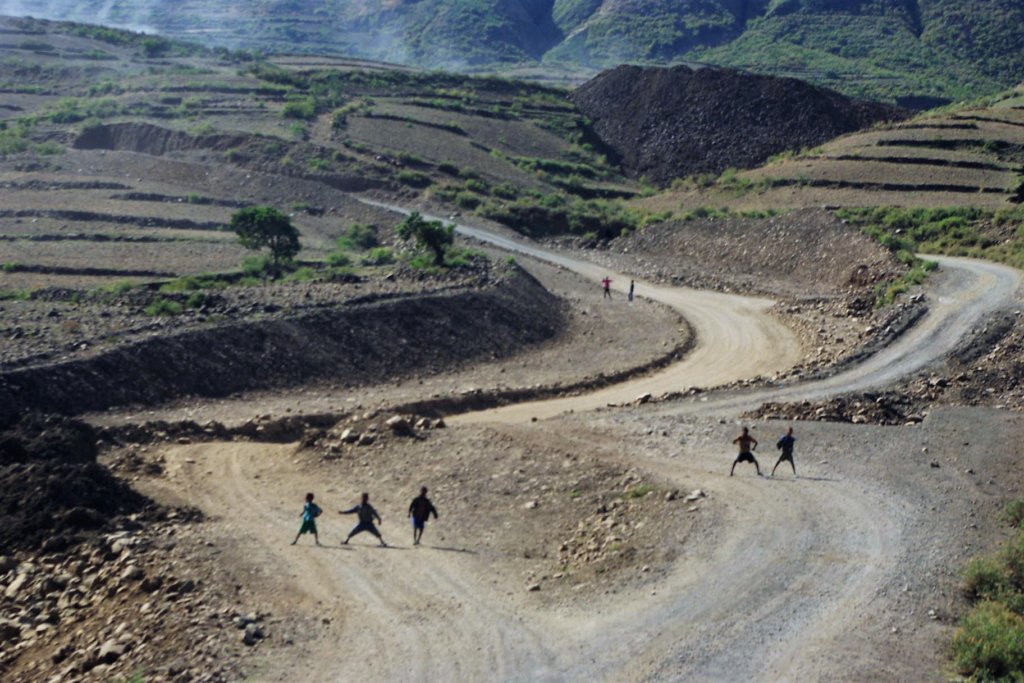 This photo shows two groups of children dancing in the road ahead of our truck