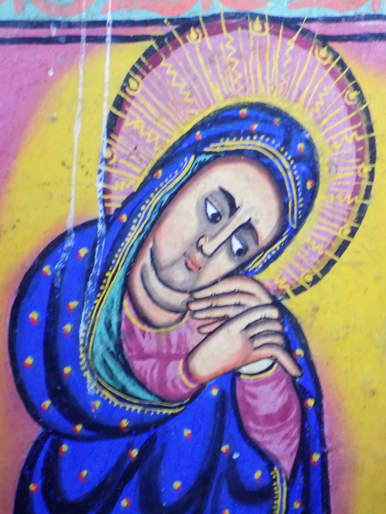 This photo shows a painting of Mary, dressed in blue, with a very sad expression on her face