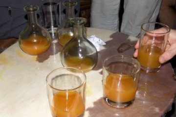 This photo shows flasks and glasses filled with golden tej (honey wine)