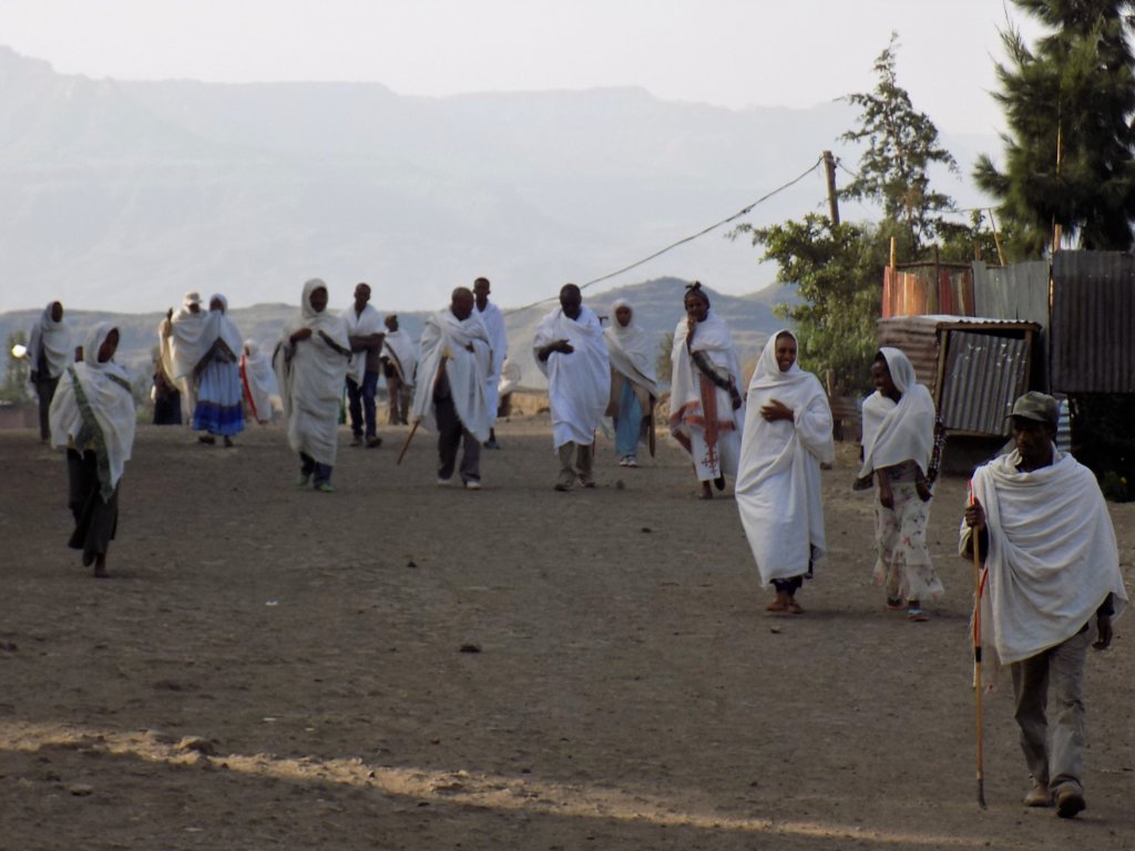 This photo shows people in white robes walking to church