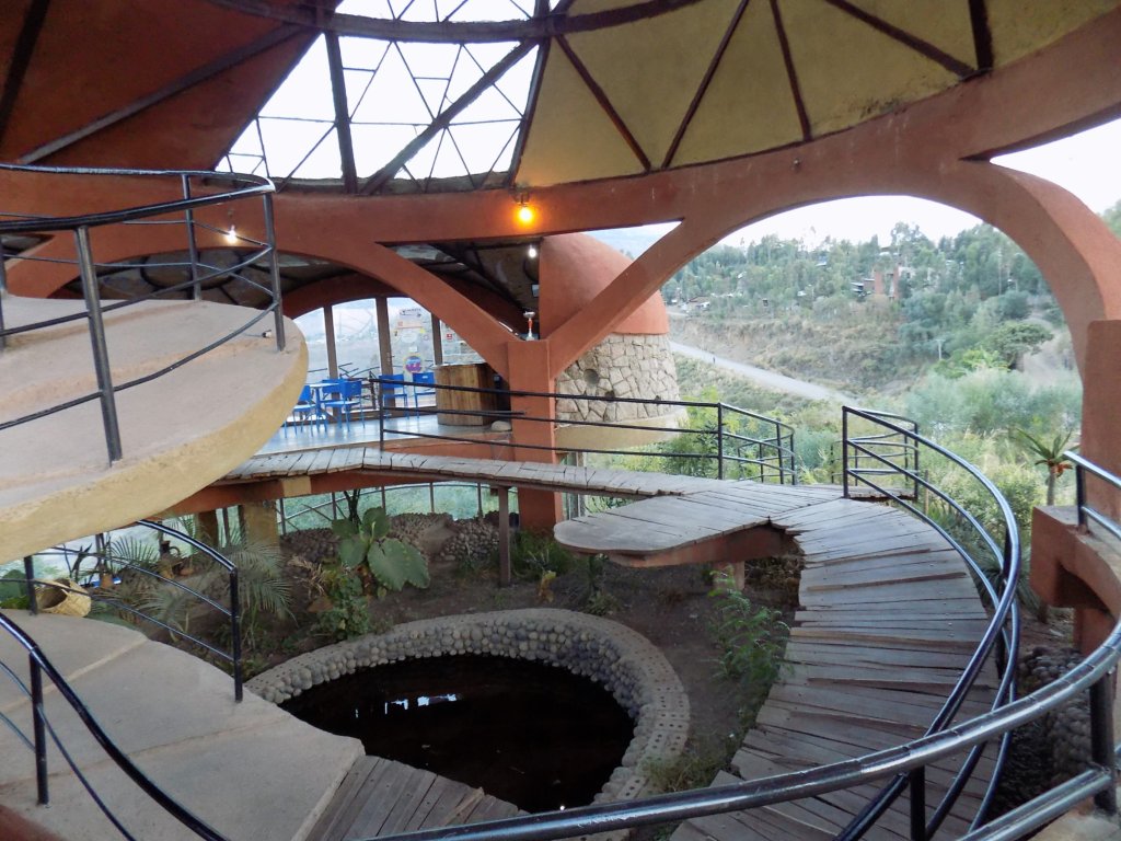 This photo shows the inside of the restaurant with a spiral wooden walkway leading to the dining pods