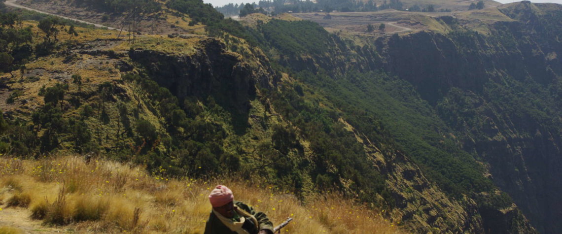 This photo shows an off-duty armed guard relaxing in the Simien Mountains, Ethiopia