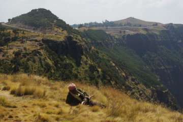 This photo shows an off-duty armed guard relaxing in the Simien Mountains, Ethiopia