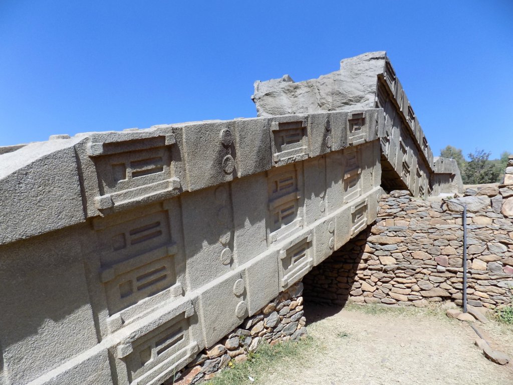 This photo shows a stele broken into two pieces lying on the ground