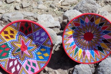 This photo shows two large shallow baskets displayed for sale