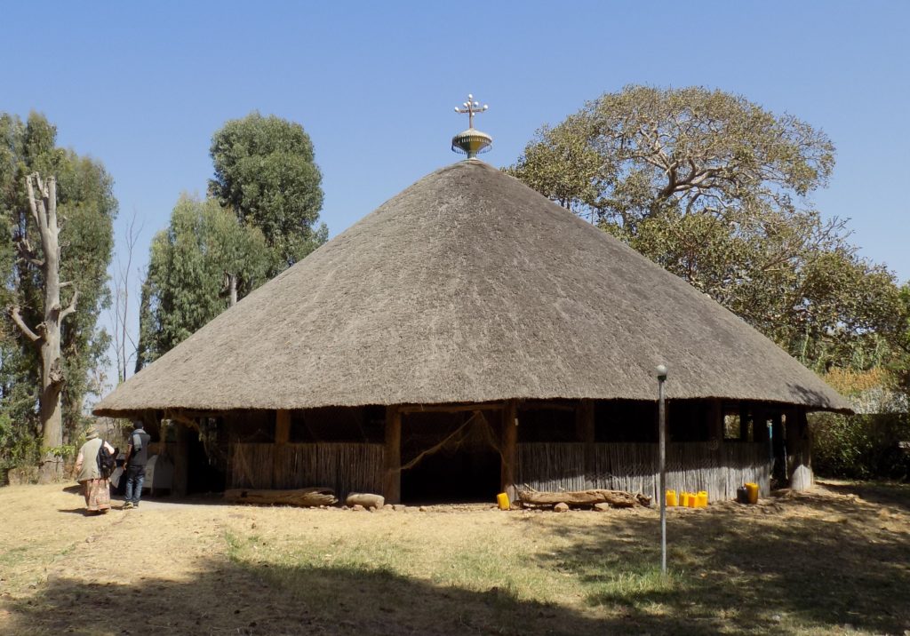 This photo shows Debre Sina Church, a large circular building with a thatched roof