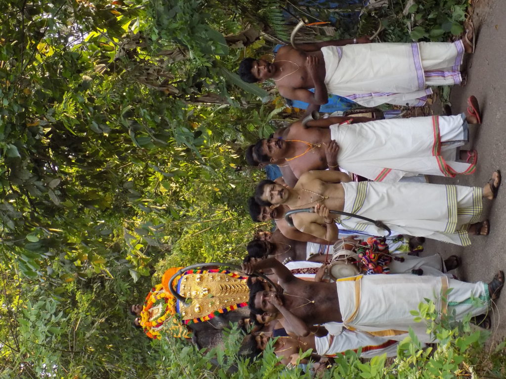 This photo shows local men dressed in white sarongs leading an elephant to the temple