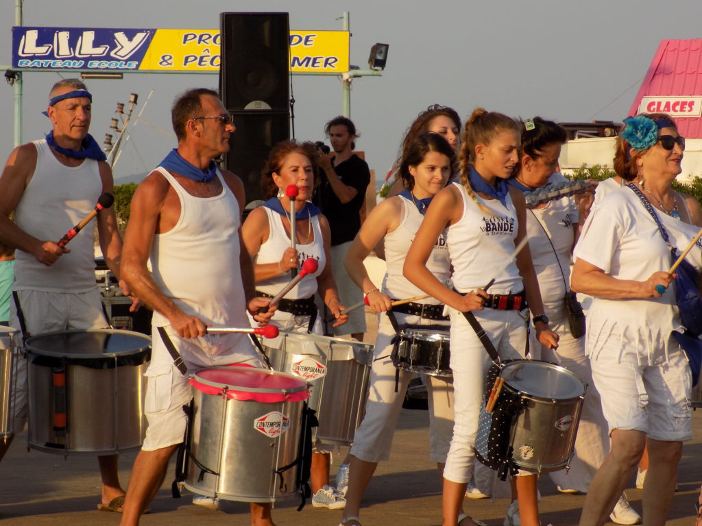 This photo shows a group of drummers dressed in white performing at the St Pierre Festival