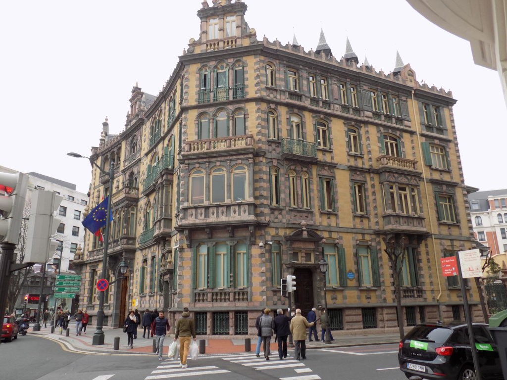 This photo shows a typical 5-storey Bilbao 19th century building located on a busy junction.