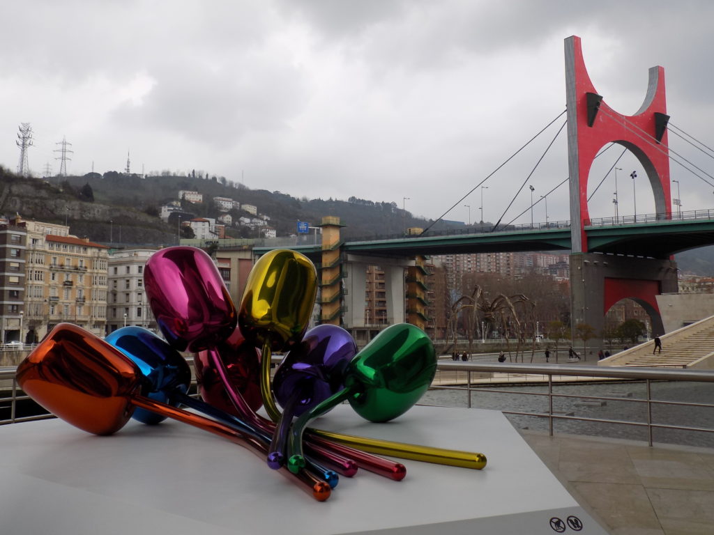 This photo shows the colourful Tulips sculpture by Jeff Koon made up of metallic-looking orange, blue, pink, yellow, purple and green tulips.