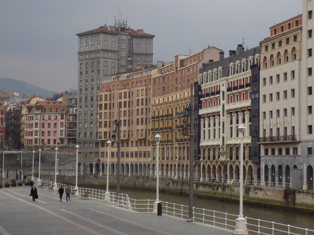 This photo shows a row of apartment buildings next to the river in central Bilbao