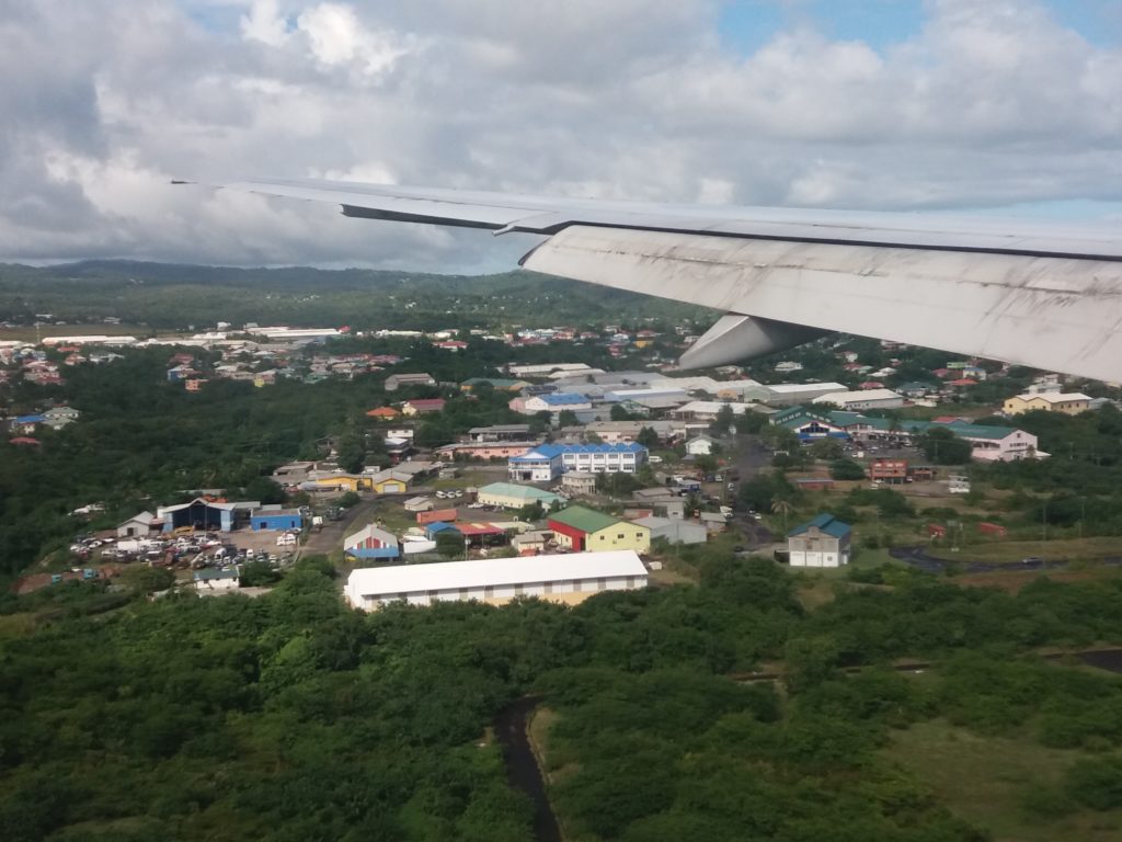 This image shows our approach to landing in Trinidad. It was taken from the window on our flight from London Gatwick to Port of Spain, Trinidad. You can see buildings, but the overwhelming impression is of the lush, green rainforest.