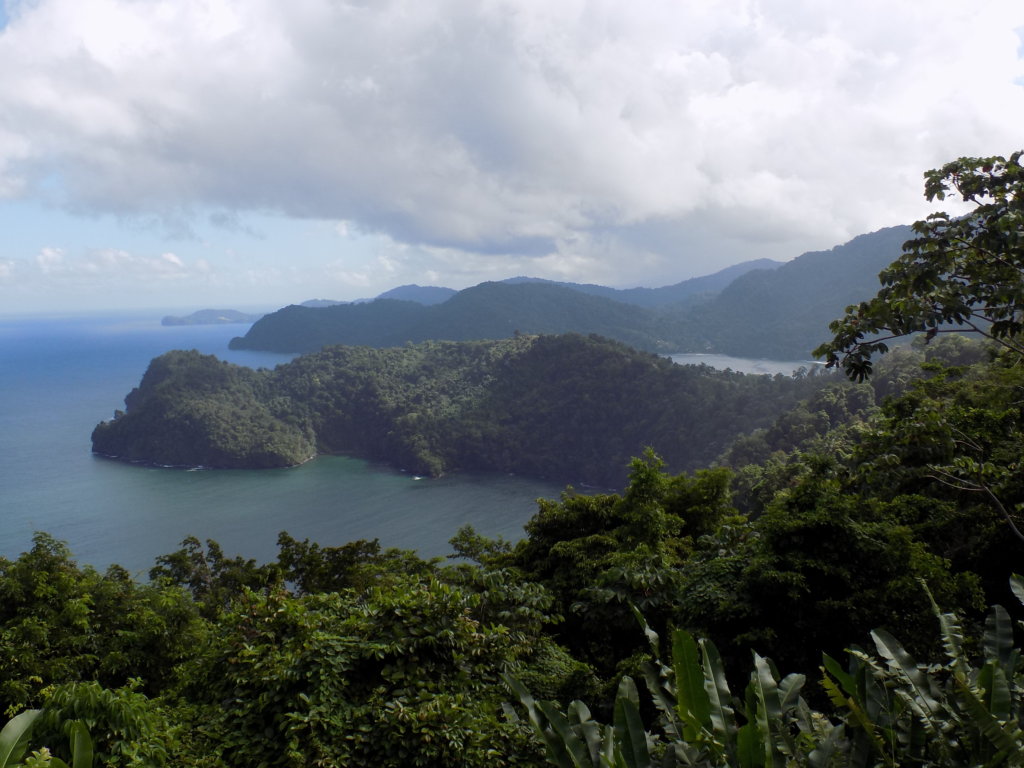 A picture of the view from La Vache Scenic Area, North Coast Road, Trinidad showing two small lush green islands in the middle of the blue Caribbean Sea. 