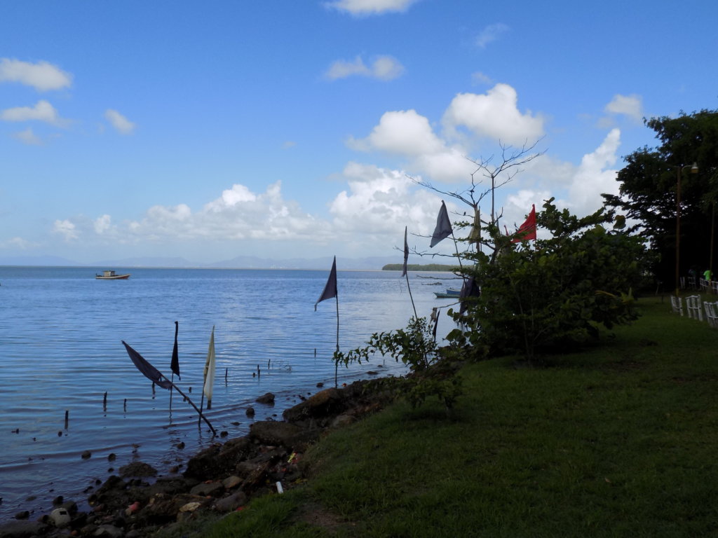 This photo shows prayer flags, coconut shells and broken pots left by worshippers at the Temple in the Sea.