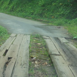 This picture shows a road in Trinidad where the tarmac had run out and had been replaced with wooden planks laid over the bare earth!