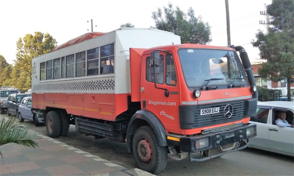 This photo shows distinctive orange and white Dragoman truck in the traffic of Addis Ababa 
