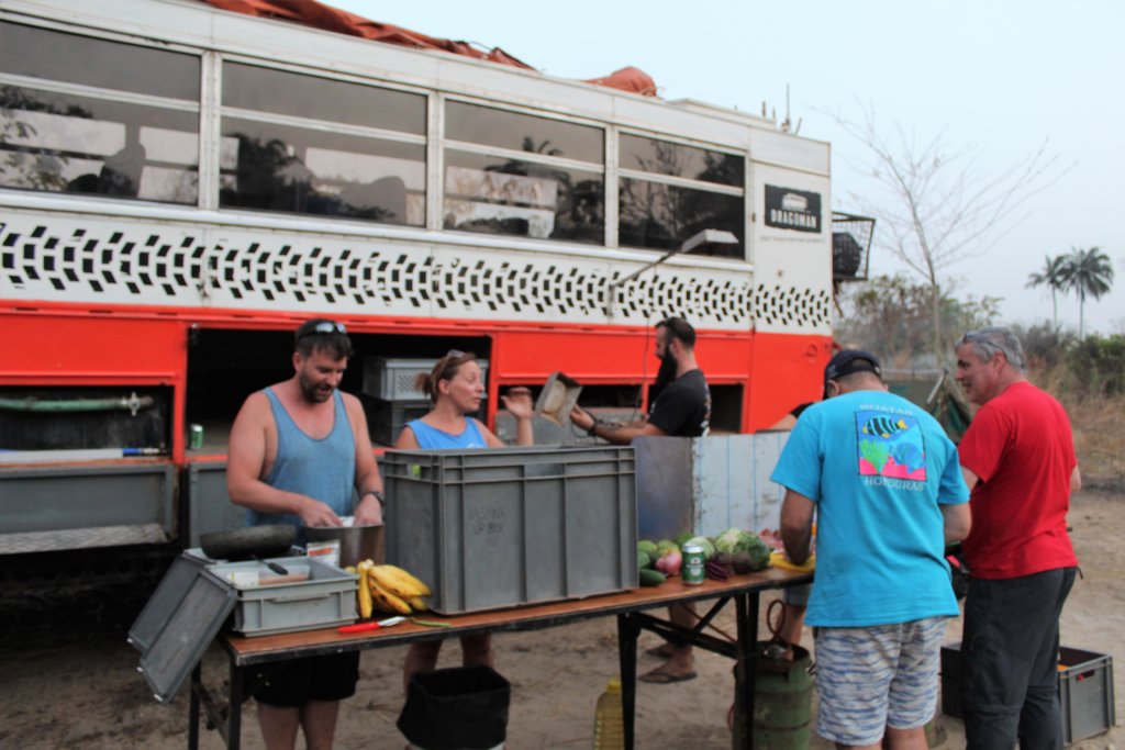 This picture shows Dragoman passengers preparing dinner in front of the truck