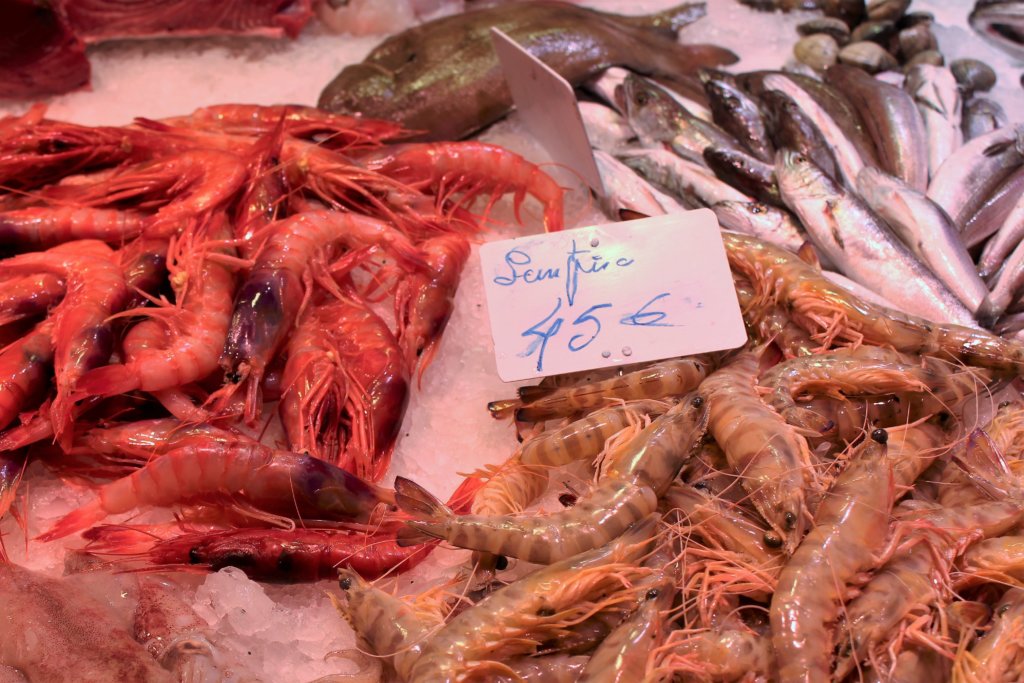 This picture shows prawns for sale inLa Boqueria Market, Barcelona. The fresh ones are darker in colour - almost red. The ones that have been frozen are much paler salmon pink. 