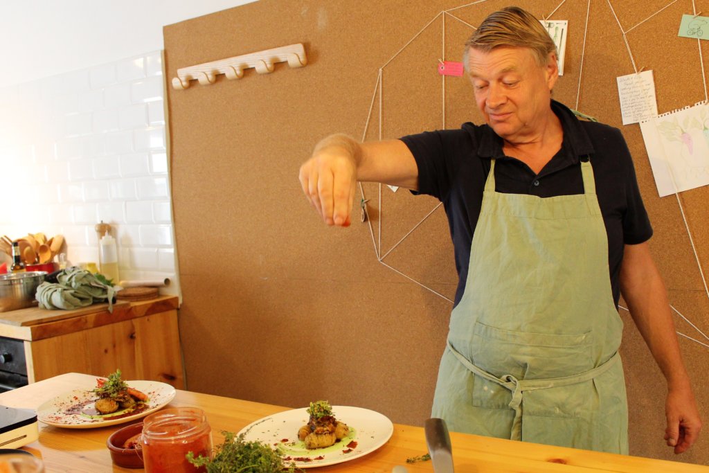 This picture shows Mark sprinkling herbs onto his finished plate of fish and chips