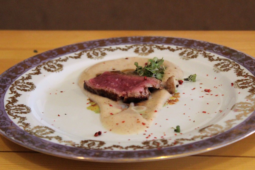 This photo shows a fillet steak sitting on a pool of parsnip cream