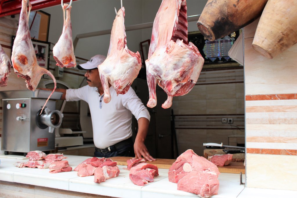 This photo shows lamb carcasses and joints on display in a butcher's shop
