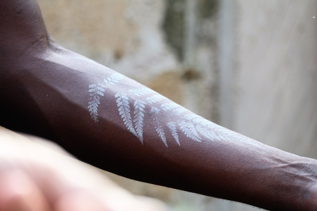 This photo shows our guide's black arm with the imprint of a fern in white