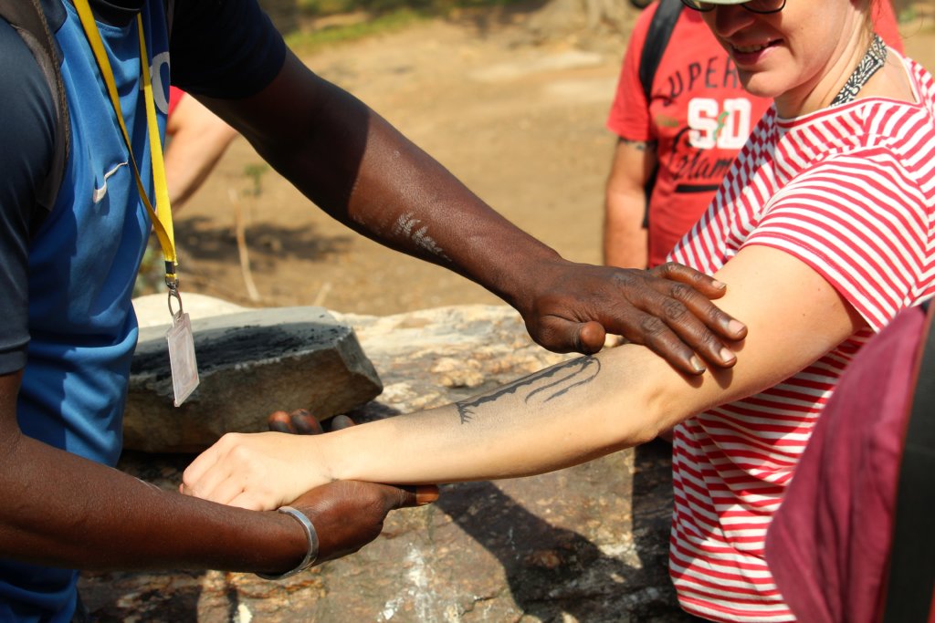 This picture shows our guide applying ash to Tina's arm to reveal her tattoo