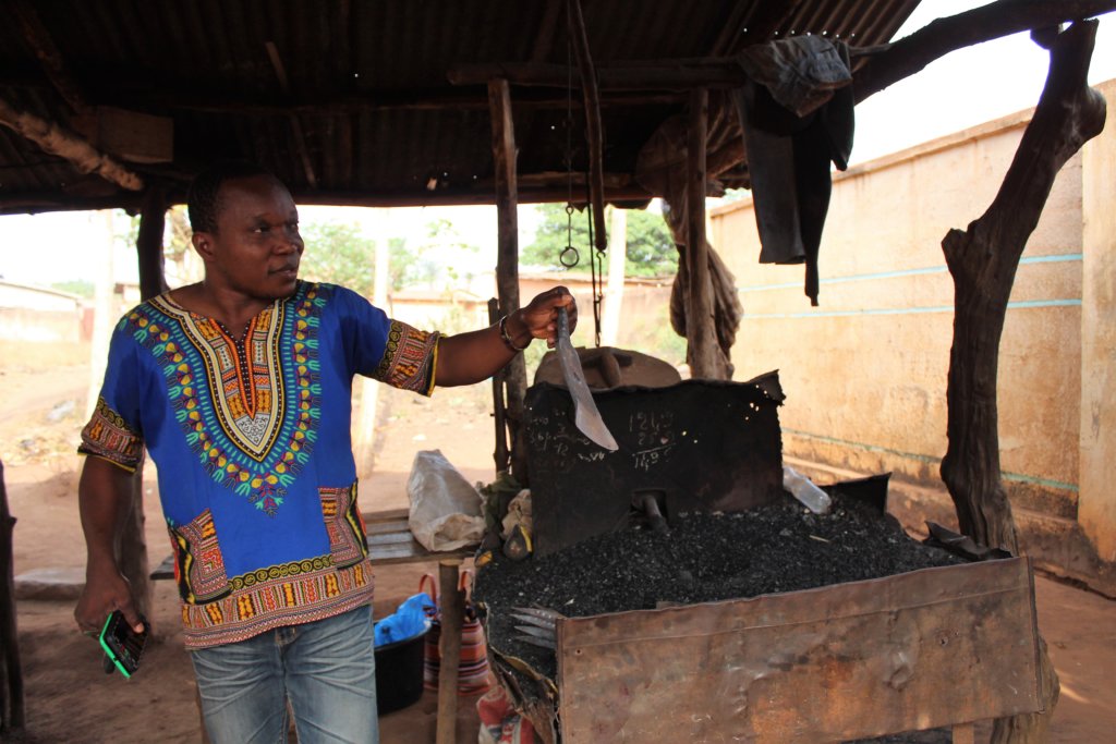 This photo shows Constance holding up a large blade that has been made in the forge