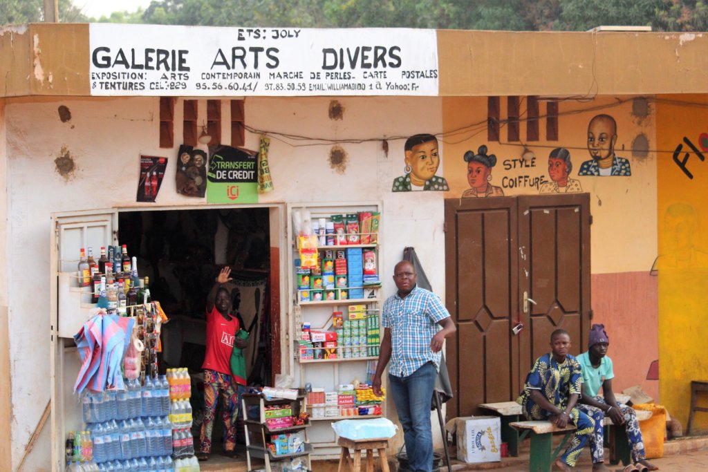 This picture shows a couple of shops with hand-painted signs in Abomey