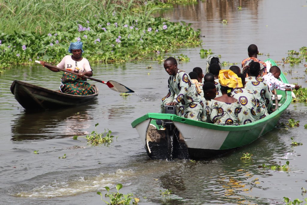This photo shows a family in their boat. They are all dressed in outfits made from the same fabric