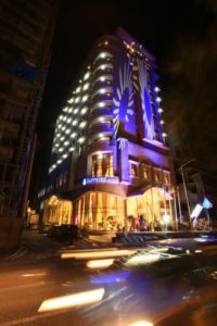 This photo shows the exterior of the Sapphire Addis Hotel illuminated at night