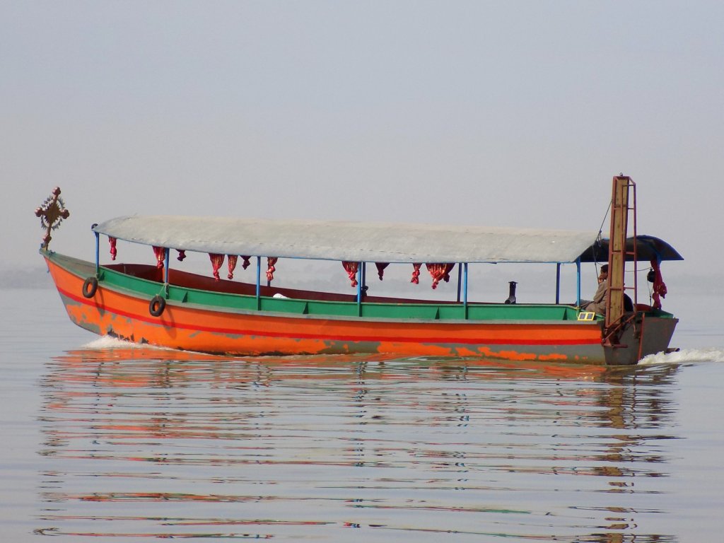 This photo shows an orange and green motor boat on Lake Tana