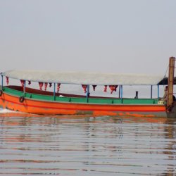 This photo shows an orange and green motor boat on Lake Tana