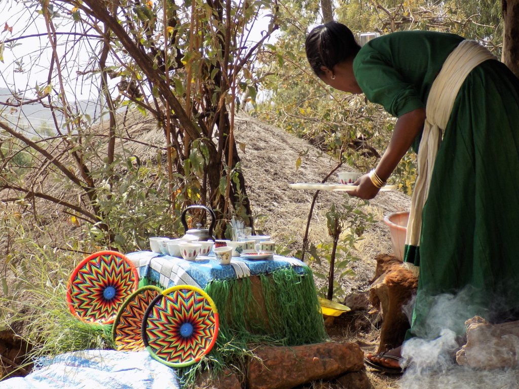 This photo shows a lady preparing coffee in the traditional way