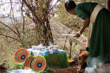 This photo shows a lady preparing coffee in the traditional way