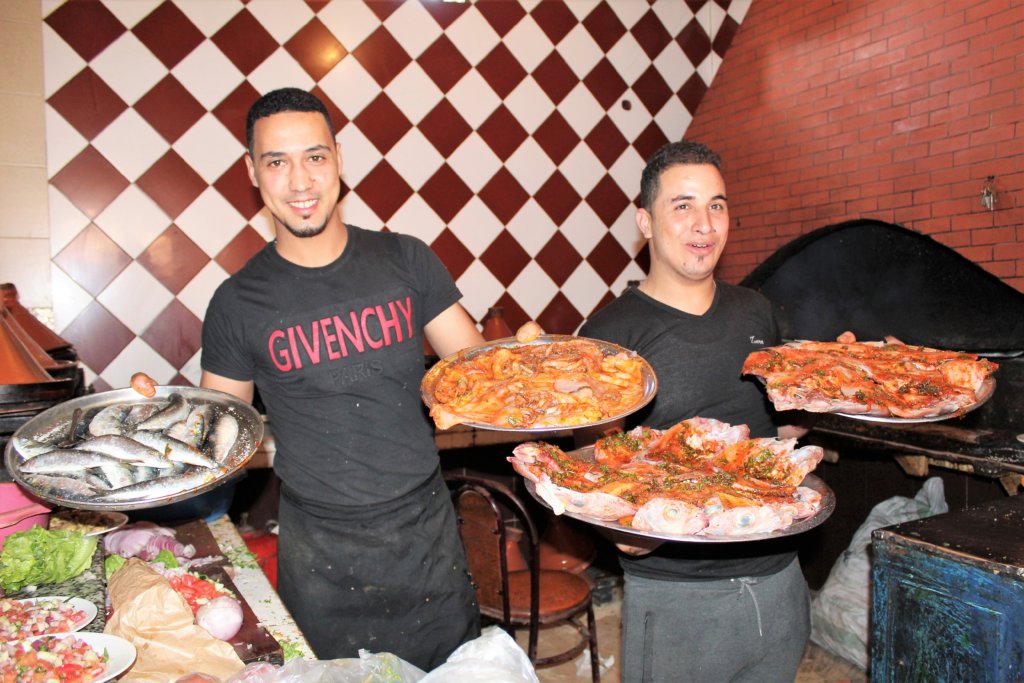 This photo shows two brothers proudly holding platters of seafood before they cooked it for us