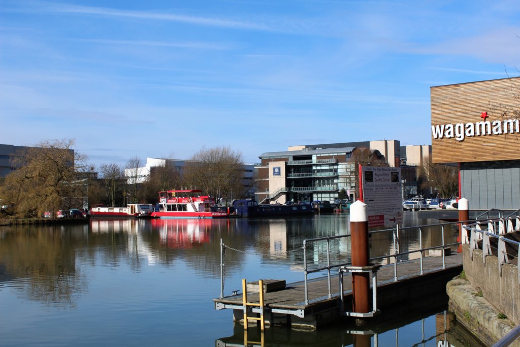 This photo shows the clear waters of Brayford Pool on a sunny day with clear reflections of the buildings and the boats