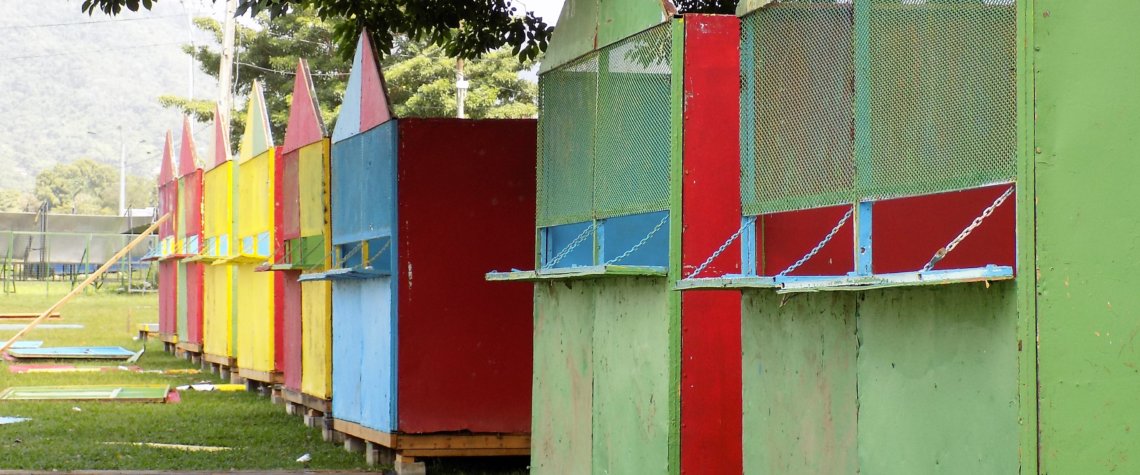 This photo shows colourful wooden huts erected on the edge of Queen's Park Savannah