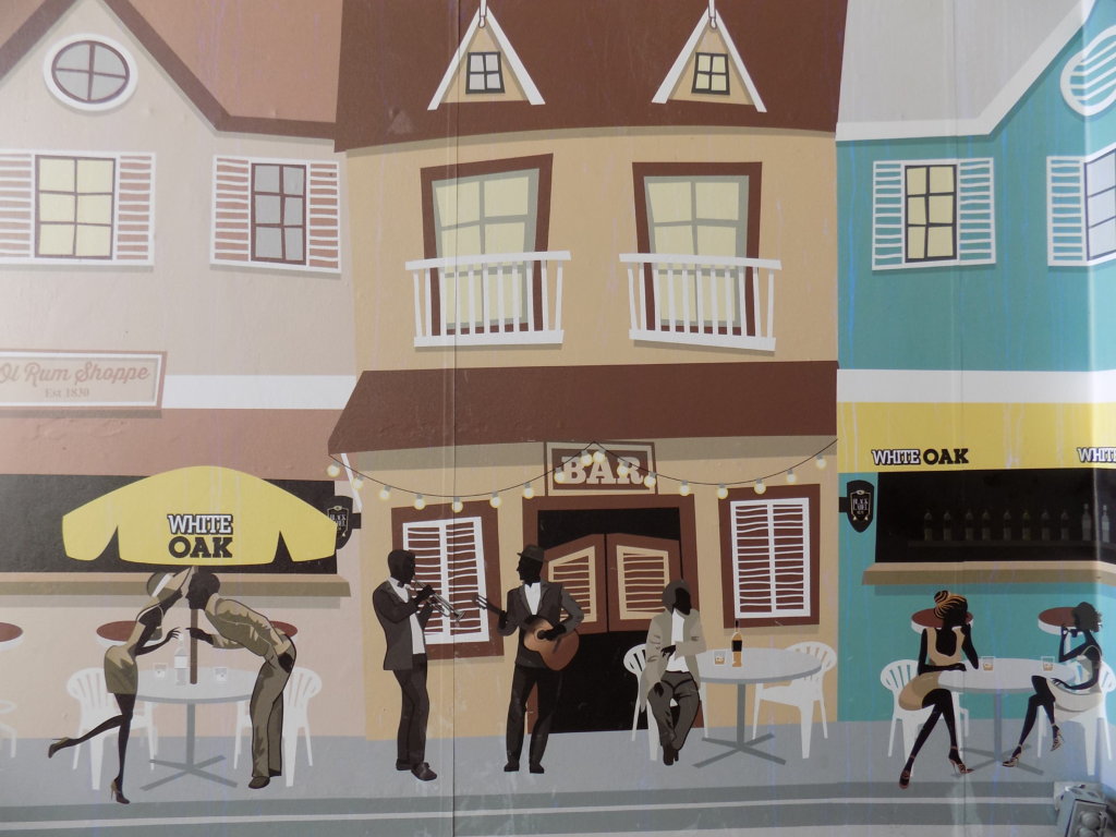 This photo shows a mural of a street scene with people socialising and drinking rum