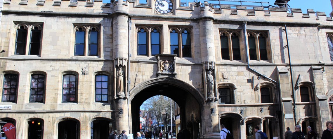 This photo shows the impressive Guildhall in Lincoln complete with its crenallated roof and archway leading to the High Street