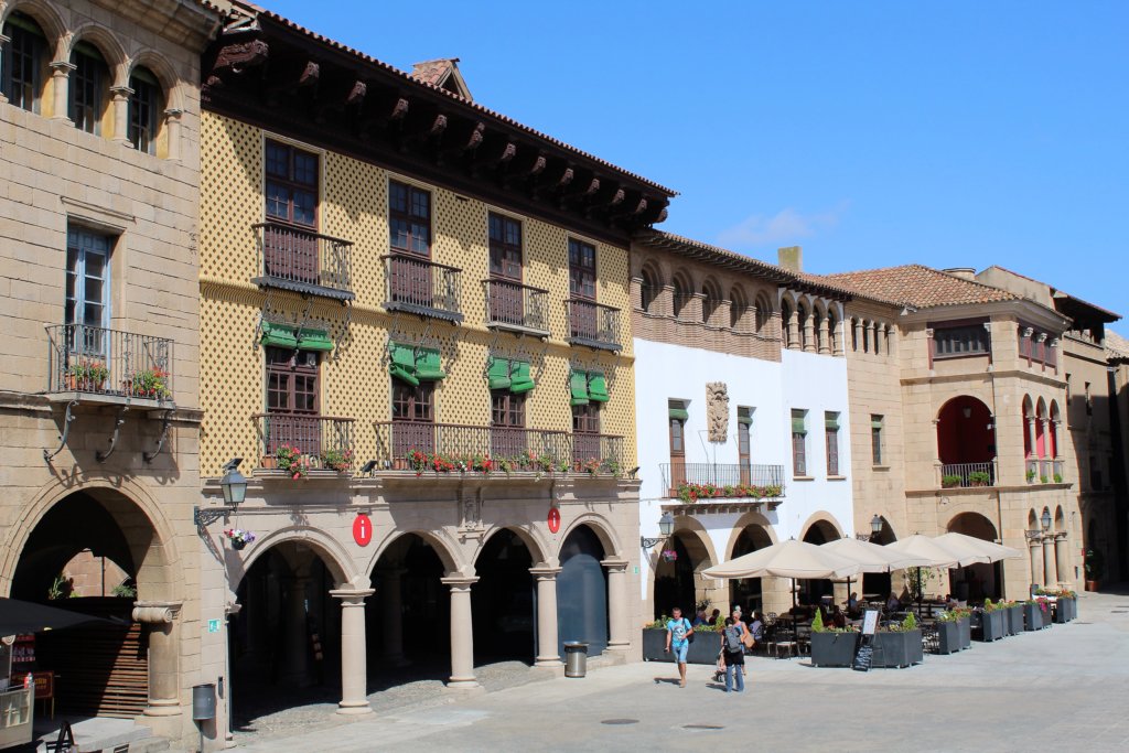 This photo shows traditional Spanish buildings with archways on the ground floor