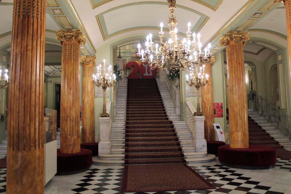 This photo shows the beautiful lobby of the Liceu with its marble columns and elaborate crystal chandeliers