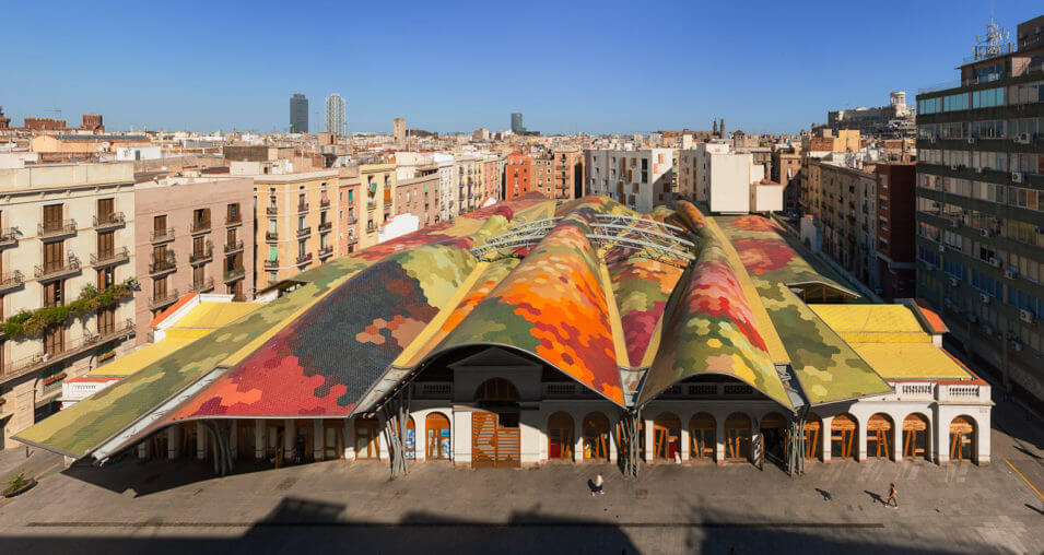 This photo shows the multi-coloured wavy roof of the market